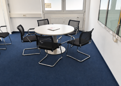 Besprechungsraum der IN&D Team GmbH in München mit rundem Tisch und Sitzplätzen für Kundengespräche